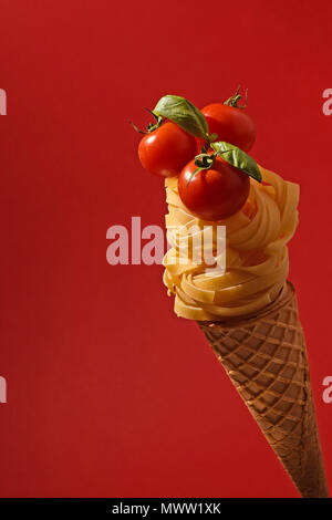 Tagliatelle mit Cherry Tomaten auf einem Kegel wie ein Eis Stockfoto