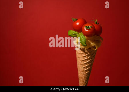 Tagliatelle mit Cherry Tomaten auf einem Kegel wie ein Eis Stockfoto