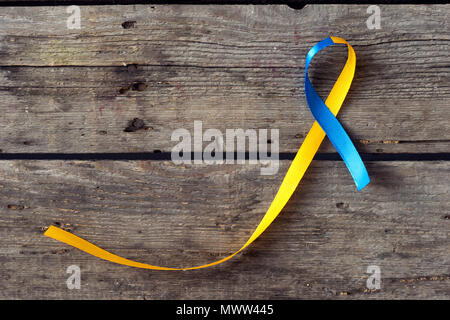 Down Syndrom Tag blauen und gelben Band auf Holz- Hintergrund Stockfoto