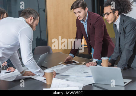 Gruppe von Architekten zusammen auf Baupläne im modernen Büro Stockfoto