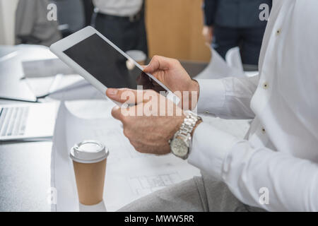 7/8 Schuß des Architekten Tablet über Baupläne Stockfoto