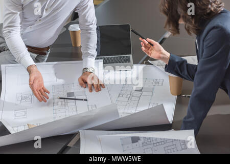 Zusammen 7/8 der Mannschaft der erfolgreichen Architekten diskutieren Baupläne Stockfoto