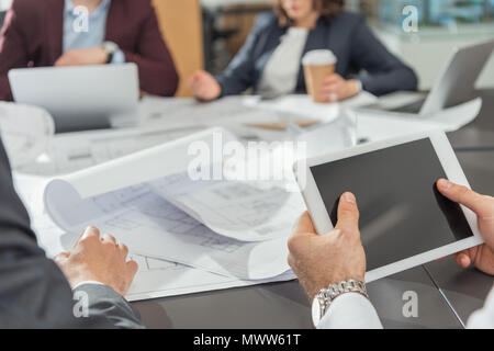 7/8 Schuß des Architekten mit Tablette während Konferenz Stockfoto