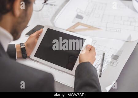 7/8 Schuß von jungen Architekten mit Tablet-PC am Arbeitsplatz Stockfoto