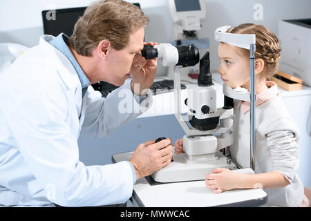 Augenarzt untersuchen Vision von jugendlicher Kind mit spaltlampe in Klinik Stockfoto