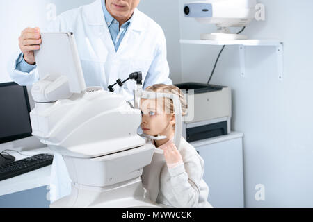 Zugeschnittenes Bild der Augenarzt untersuchen Vision von jugendlicher Kind in Klinik Stockfoto