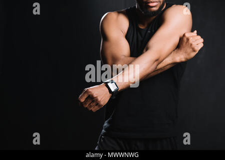 7/8 shot muskulöse afrikanische amerikanische Mann stretching Hände isoliert auf Schwarz Stockfoto