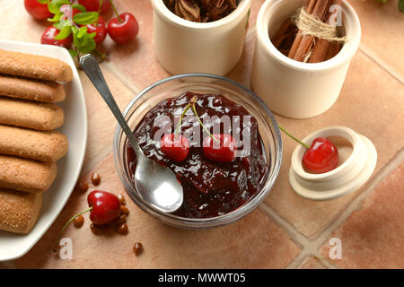 Cherry Marmelade im Glas Schale mit Früchten um: Detailansicht Stockfoto