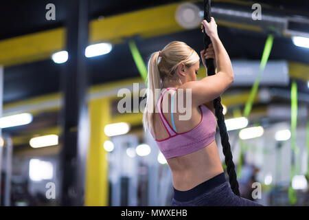 Junge muskulöse Frau, Seil klettern in Cross Fitness Gym Stockfoto