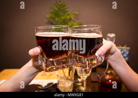 Zwei Gläser mit Alkohol in den Händen Stockfoto