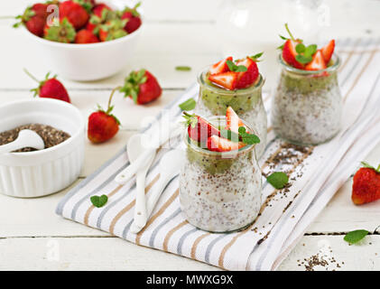 Detox und gesunden superfoods Frühstück im Glas. Vegan Kokosmilch Chia Samen Pudding mit Erdbeeren und Kiwis. Stockfoto