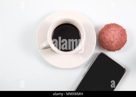 Ansicht von oben, den Espresso in weiße Tasse mit hausgemachten Brownie muffin Kuchen und Smartphone auf weißem Hintergrund, Kaffeepause im Konzept in Weichen Stockfoto
