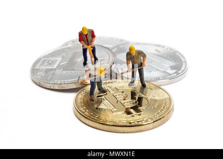 Miniatur Arbeiter Bergbau verschiedene Cryptocurrencies auf eine weiße Fläche Stockfoto