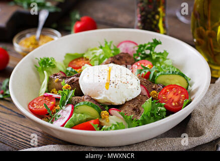 Warmer Salat vom Huhn Leber, Radieschen, Gurken, Tomaten und Eier pochiert. Gesundes Essen. Diätetisches Menü Stockfoto