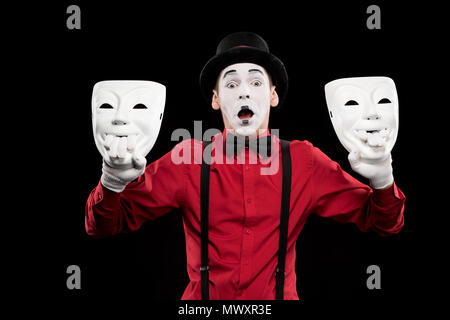 Schockiert mime-Betrieb zwei Masken isoliert auf Schwarz Stockfoto