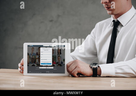 7/8 Schuß des Kaufmanns Holding digital Tablet mit Linkedin website auf dem Bildschirm Stockfoto