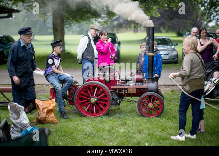 Ein kleiner Junge sitzt auf eine handgemachte Dampfmaschine am Himley Hall vintage Messe in Dudley, West Midlands. Stockfoto