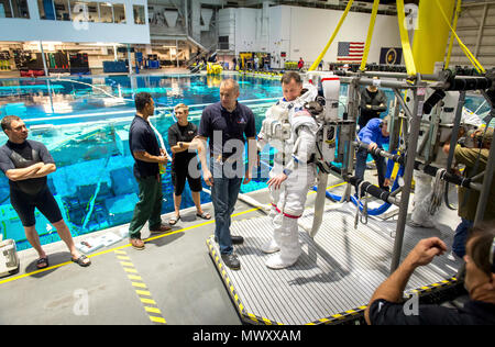 Canadian Space Agency astronaut David Saint Jacques hilft Astronaut Oberst Tyler N. 'Nick' Haag bereiten in einen Pool mit einem Modell der Internationalen Raumstation (ISS) für Extra Vehicular Activity (EVA) Ausbildung bei Neutralstellung des Johnson Space Flight Center Buoyancy Laboratory (NBL) in Houston, Tex, April 27, 2017 gesenkt werden. Während der Ausbildung bei der NBG, Haag einen Raumanzug trägt, die in der Nähe von Schwerelosigkeit er Begegnung wird während der Durchführung von EVAs, oder außenbordeinsätze zu simulieren, während sie als Flugingenieur an Bord der ISS-Expedition 54/55 in 2018-2019. Stockfoto