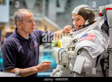 Canadian Space Agency astronaut David Saint Jacques hilft Astronaut Oberst Tyler N. 'Nick' Haag bereiten in einen Pool mit einem Modell der Internationalen Raumstation (ISS) für Extra Vehicular Activity (EVA) Ausbildung bei Neutralstellung des Johnson Space Flight Center Buoyancy Laboratory (NBL) in Houston, Tex, April 27, 2017 gesenkt werden. Während der Ausbildung bei der NBG, Haag einen Raumanzug trägt, die in der Nähe von Schwerelosigkeit er Begegnung wird während der Durchführung von EVAs, oder außenbordeinsätze zu simulieren, während sie als Flugingenieur an Bord der ISS-Expedition 54/55 in 2018-2019. Stockfoto