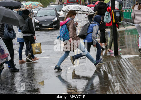 Fußgänger über eine Pfütze an der Kreuzung außerhalb des Parlaments durch Regen verursachte springen. Mit: Atmosphäre, Wo: London, Großbritannien Wann: 02. Mai 2018 Credit: Dinendra Haria/WANN Stockfoto