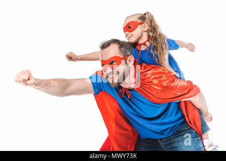 Gerne Vater und Tochter in der Superhelden Kostüme vorgibt, auf weissem isoliert zu fliegen Stockfoto