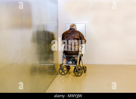 Älterer Mann sitzt auf seinem Wanderer warten Stockfoto