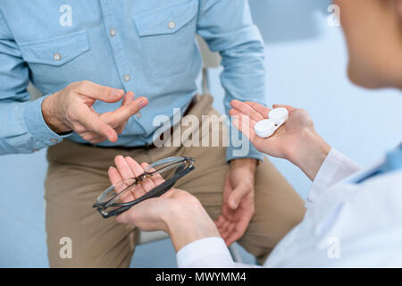 7/8-Ansicht der Augenarzt holding Brillen und Kontaktlinsen Stockfoto