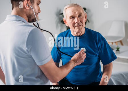 Rehabilitation Therapeut mit Stethoskop Überprüfung älterer mans Heartbeat Stockfoto