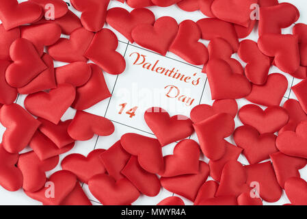 Viele rote Seide Herzen auf dem calendarwith die Inschrift Valentinstag. Hintergrund für eine Grußkarte für Valentinstag Erz wallpaper Stockfoto