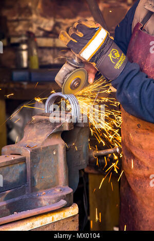 Schmied bei der Arbeit in der alten Schmiede in Cockington Schmiede in Devon. Stockfoto