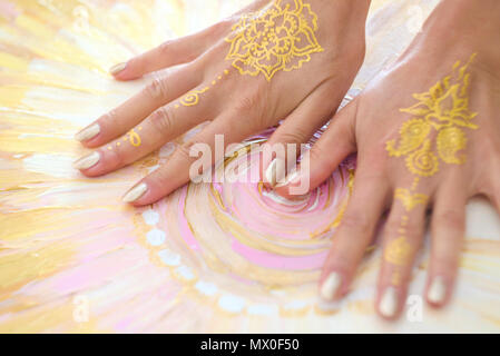 Zwei offene leere Mehndi Hände mit den Handflächen nach unten auf gemalten Hintergrund isoliert. Gold Muster. Die Kunsttherapie. Stockfoto