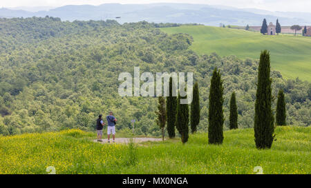 San Quirico d'Orcia, Italien, 10. Mai 2018; zwei Männer eine Drohne in der Nähe der Kapelle Vitaleta Fliegen, ist sichtbar im Hintergrund. Stockfoto