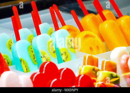 Arrangiert Thirteen fruchtig; Kiwi, Erdbeeren, Berry, Drachenfrucht, Papaya, Mango, Minze, Schokolade, Milch, Orange, Ananas Eis stick, in froz eingefroren Stockfoto