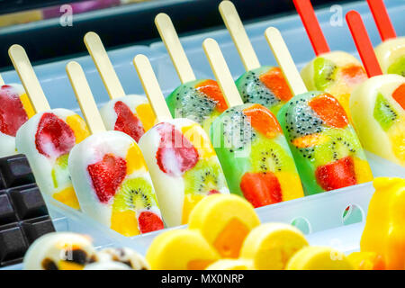 Arrangiert Thirteen fruchtig; Kiwi, Erdbeeren, Berry, Drachenfrucht, Papaya, Mango, Minze, Schokolade, Milch, Orange, Ananas Eis stick, in froz eingefroren Stockfoto