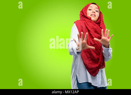 Junge arabische Frau, tragen, Hijab angewidert und wütend, halten die Hände in stop Geste, als Verteidigung, schreien Stockfoto