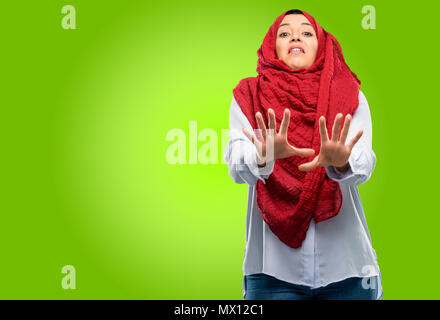 Junge arabische Frau, tragen, Hijab angewidert und wütend, halten die Hände in stop Geste, als Verteidigung, schreien Stockfoto