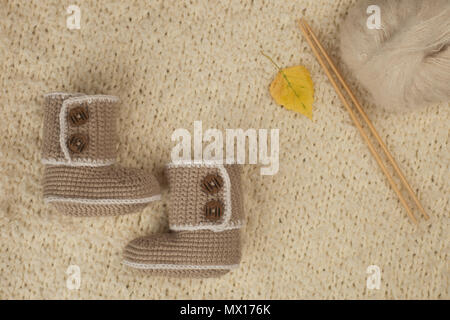 Garn Kugeln. Holz- Nadeln stricken. Stricken Zubehör und Hand knetted Booties auf weichen wollen Hintergrund Stockfoto