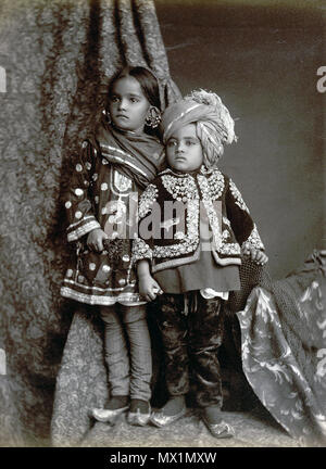 . Englisch: 'Kaschmir Kinder.' full-length Studio portrait einer jungen Kaschmirischen Junge und Mädchen, in der modernen Bundesstaates Jammu und Kaschmir, von einem unbekannten Fotografen in den 1890er Jahren genommen. Diese elegant gekleidete Kinder tragen Kleidung gestickt mit aufwändigen traditionellen Mustern, die durch die Schönheit der Flora und Fauna von Kaschmir inspiriert worden zu sein. Diese schöne Gegend, an der nördlichen Grenze von Indien und Pakistan ist bekannt für seine feine Schals aus Wolle, Textilien und Teppiche, die immer noch mit traditionellen Methoden, die vor Jahrhunderten hergestellt. 1. Januar 2007 (Original u Stockfoto