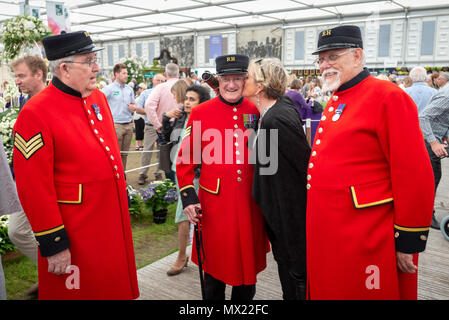 Ein Besucher der RHS Chelsea Flower Show in London, UK gibt einen Chelsea Rentner einen Kuss auf die Wange. Stockfoto