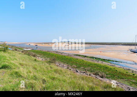 Von der Spitze eines steilen Gras Bank, mit Blick auf die Yachten in der Mündung Strand bei Ebbe. Stockfoto