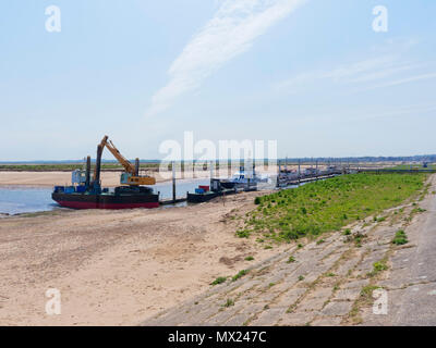 Landeinwärts in Richtung der Stadt Wells-next-the-Sea. Bei Ebbe in der Mündung der Boote und kleine Sportboote sind neben einem Steg vertäut. Stockfoto