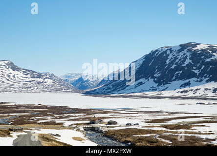 Mit Blick auf die Berge mit dem See Eldrevassbergi Eldrevatnet noch in Eis und Schnee vor. Frühling Hemsedal Norwegen. Stockfoto