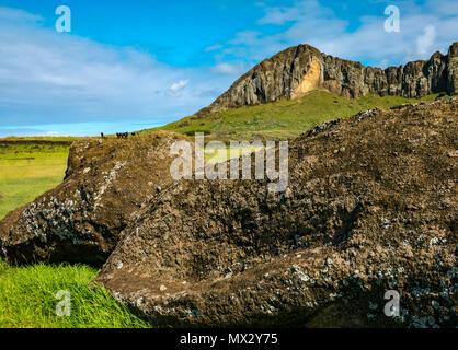 Gefallenen Moai Kopf, Tongariki archäologische Stätte mit steilen Klippen des Rano Raraku Vulkan Krater, der moai Head Quarry, Easter Island, Chile Stockfoto