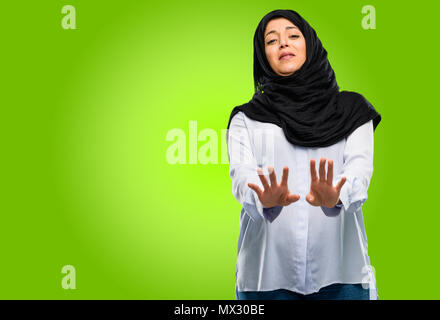 Junge arabische Frau, tragen, Hijab angewidert und wütend, halten die Hände in stop Geste, als Verteidigung, schreien Stockfoto