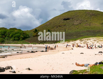 Menschen auf gekrümmten Anakena Sandy Bay Beach, Osterinsel, Rapa Nui, Chile, mit Gewitterwolken Stockfoto