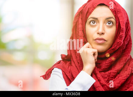 Junge arabische Frau, tragen, hijab Denken und die Suche nach Ausdruck Zweifel und Fragen Stockfoto