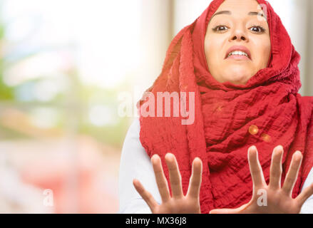 Junge arabische Frau, tragen, Hijab angewidert und wütend, halten die Hände in stop Geste, als Verteidigung, schreien Stockfoto