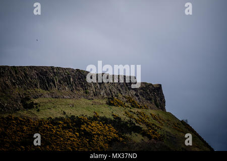 Man alleine steht, Salisbury Crags in Edinburgh während einem bewölkten Tag, Tele Stockfoto