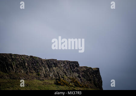 Man alleine steht, Salisbury Crags in Edinburgh während einem bewölkten Tag, Tele Stockfoto