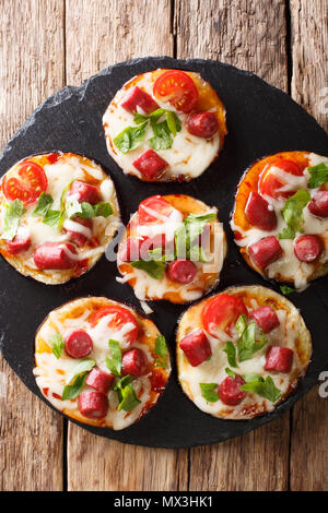 Appetitlich gebackene Auberginen mit Käse, Tomaten, Wurst und Kraut close-up auf den Tisch. Vertikal oben Ansicht von oben Stockfoto